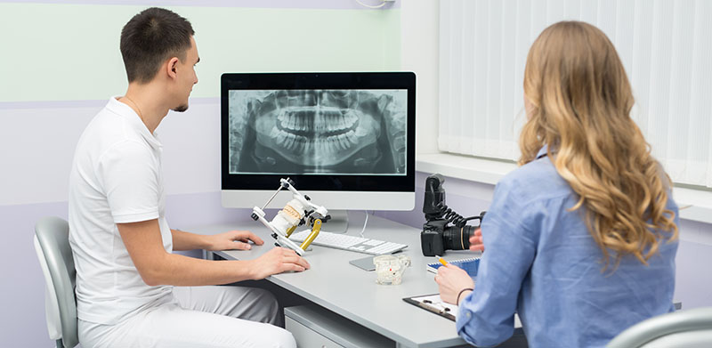 Patient and Dentist Looking at X-Rays